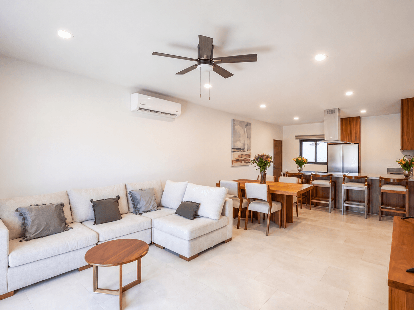 Sala de diseño contemporáneo con mobiliario confortable y conexión abierta hacia el comedor.